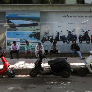 Customers sit outside an Ola service centre with their electric scooters while waiting for servicing in Bengaluru, India.
