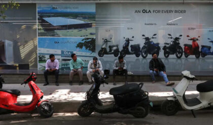 Customers sit outside an Ola service centre with their electric scooters while waiting for servicing in Bengaluru, India.