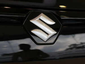 The logo of Maruti Suzuki on a e Vitara SUV car parked inside a showroom in Ahmedabad